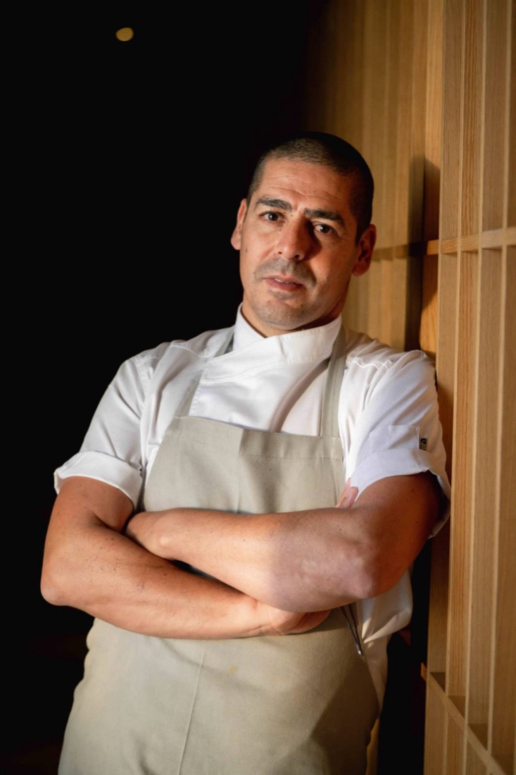 Chef Yossi Shitrit in his chef whites and apron, arms crossed